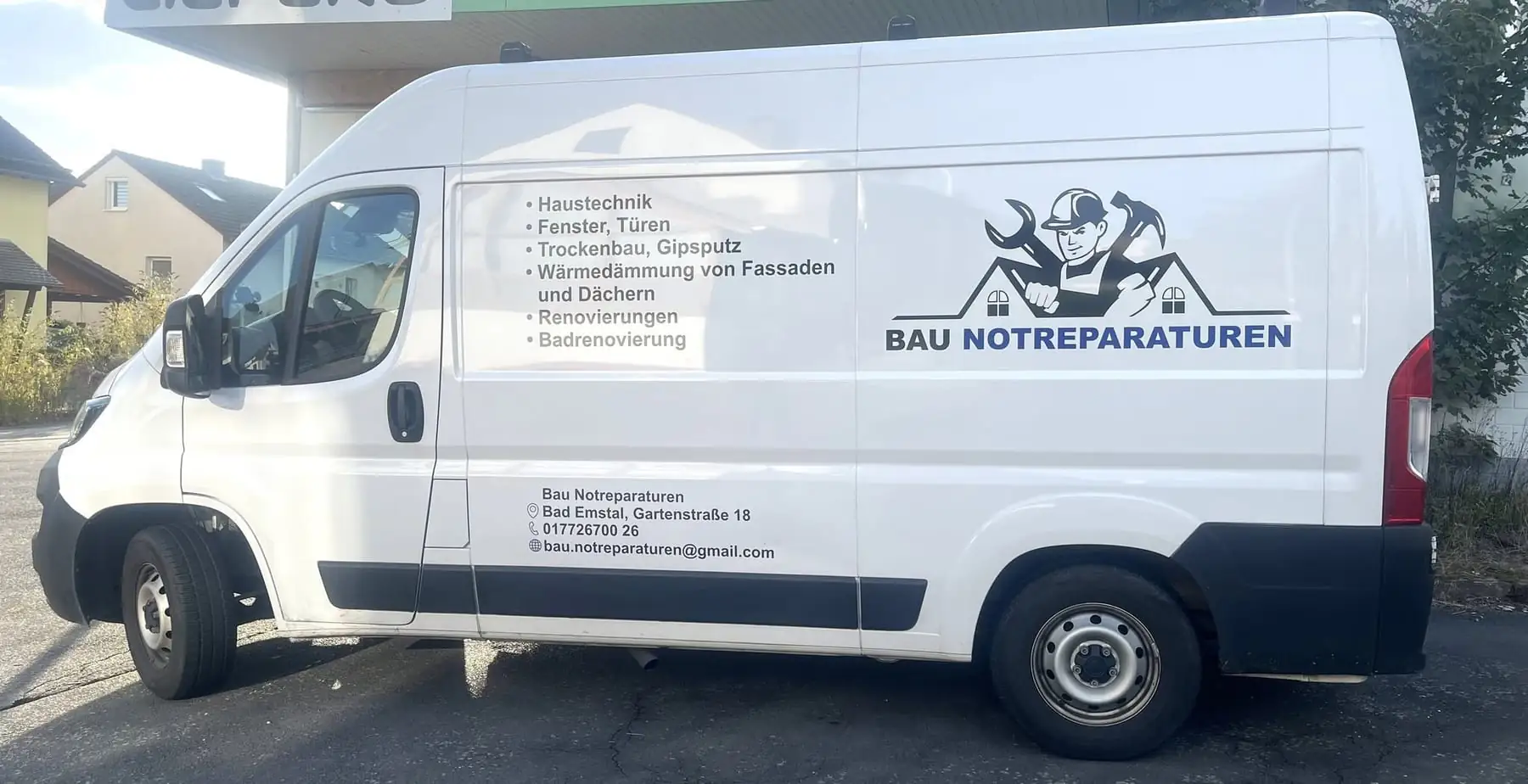 Beschrifteter Firmenwagen von Bau Notreparaturen mit der Leistungsliste auf der Seitenwand