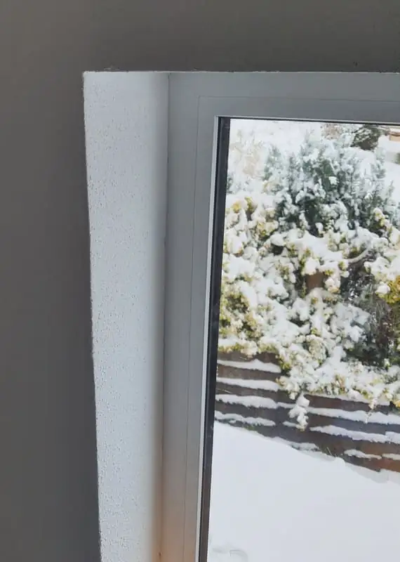 Fensterlaibung von innen mit Blick in den verschneiten Garten