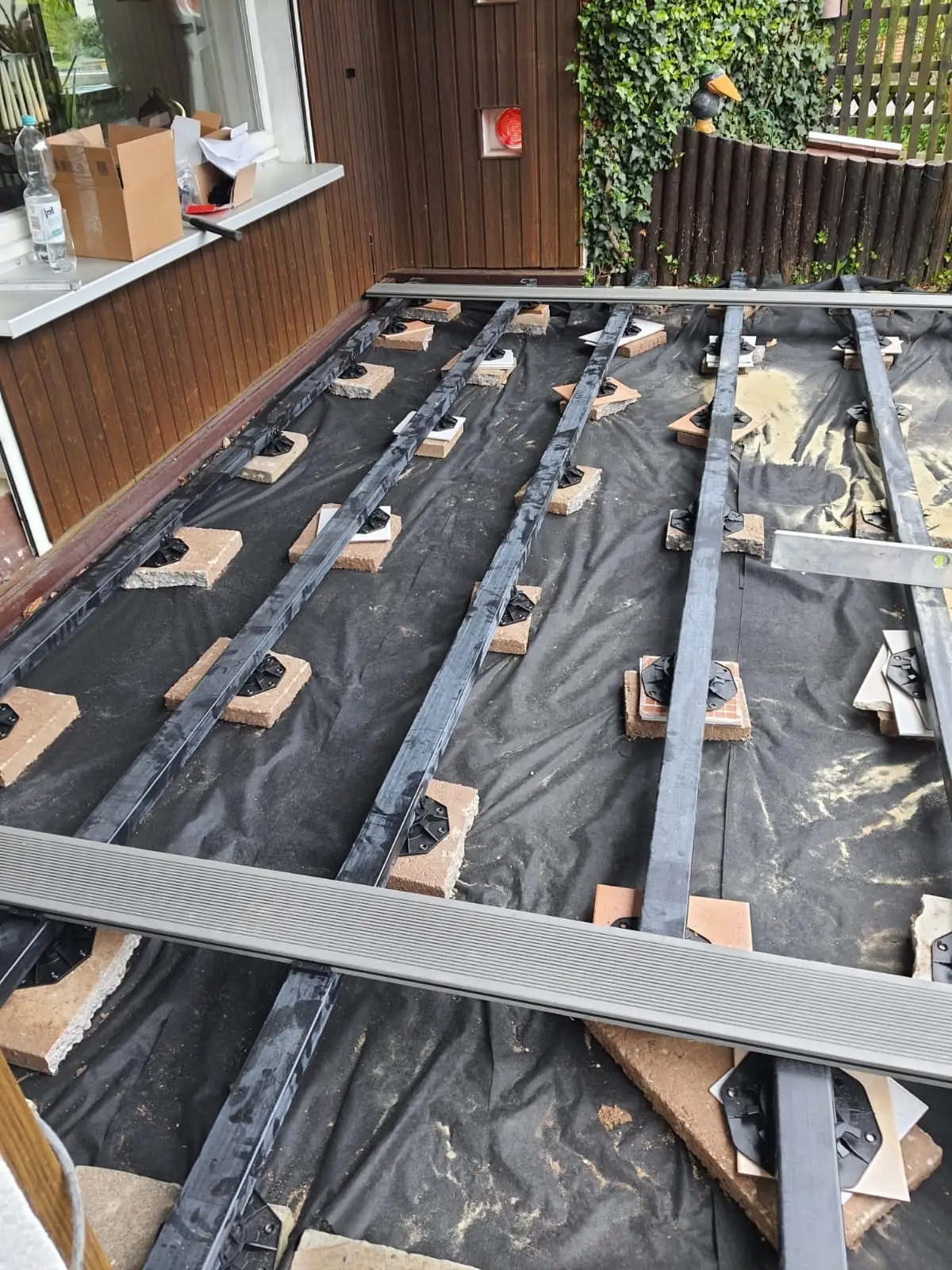 Terrasse, Etappe 2: Unterkonstruktion auf Stelzlagern, Vlies gegen Aufwuchs darunter.